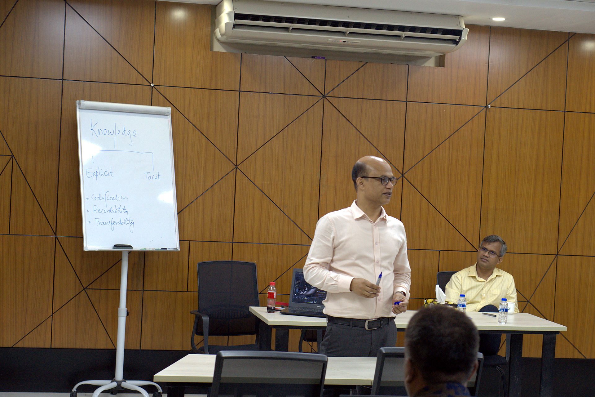 Trainer beside a flipchart in the a2i conference room