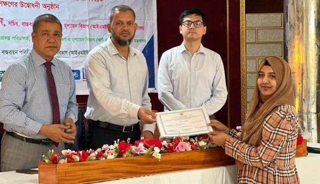 A participant receiving her certificate of completion