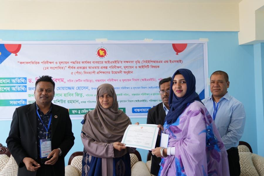A participant receiving her certificate of completion from Dr. Sitara Begum