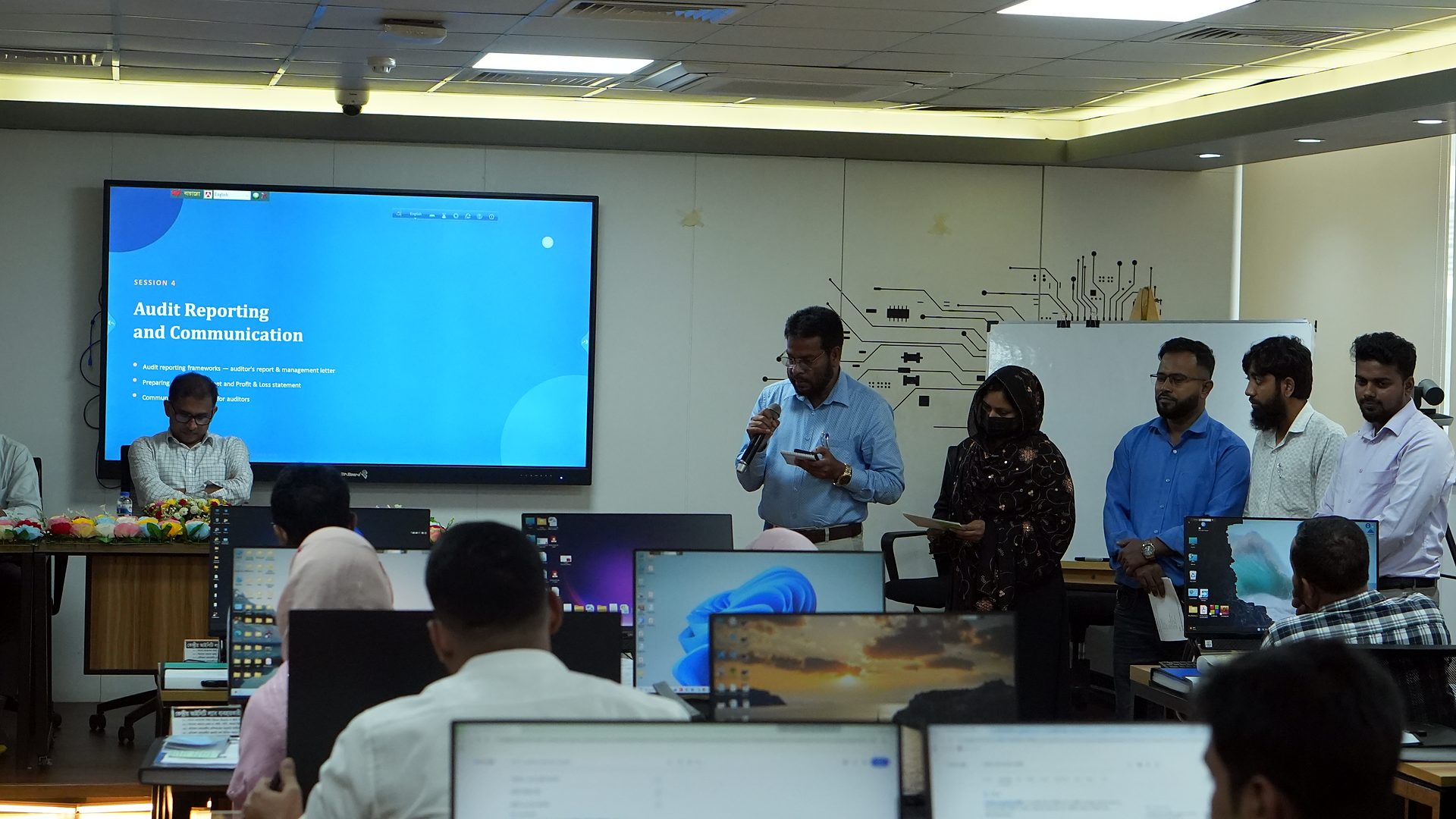 Audit Reporting and Communication slide on the lab screen with participants