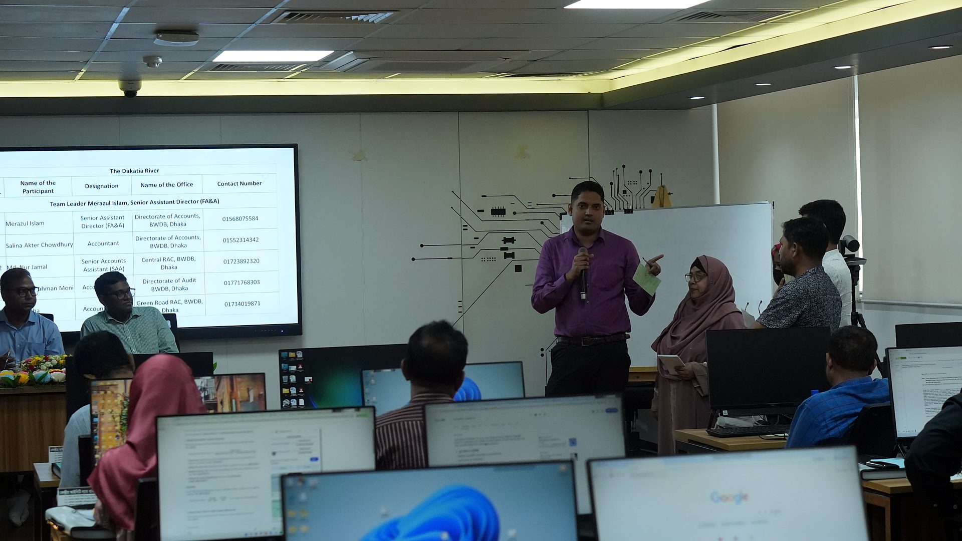 Team member presenting with a slide listing team members