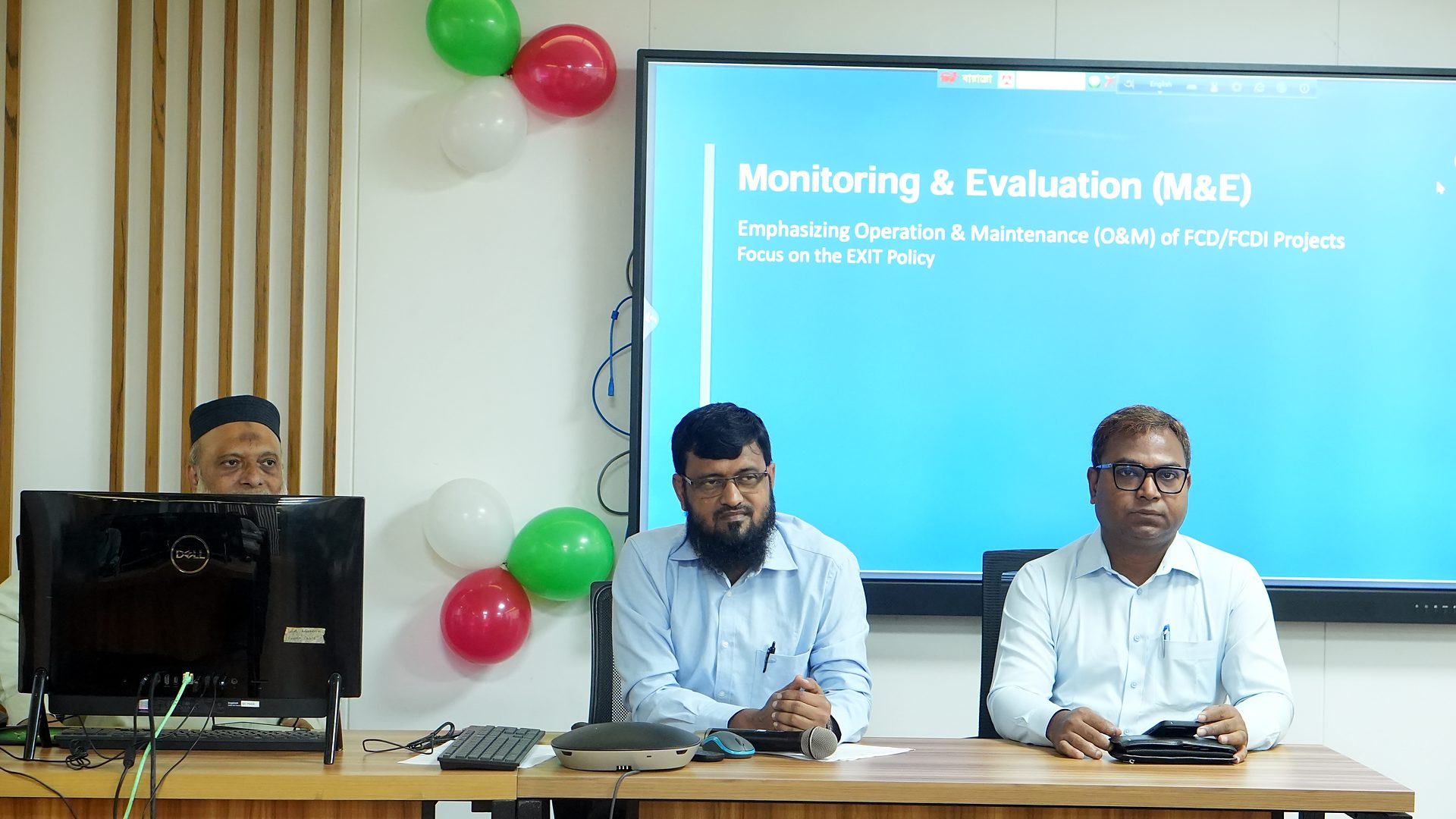 Monitoring and Evaluation of O&M session slide on screen with resource persons at the dais