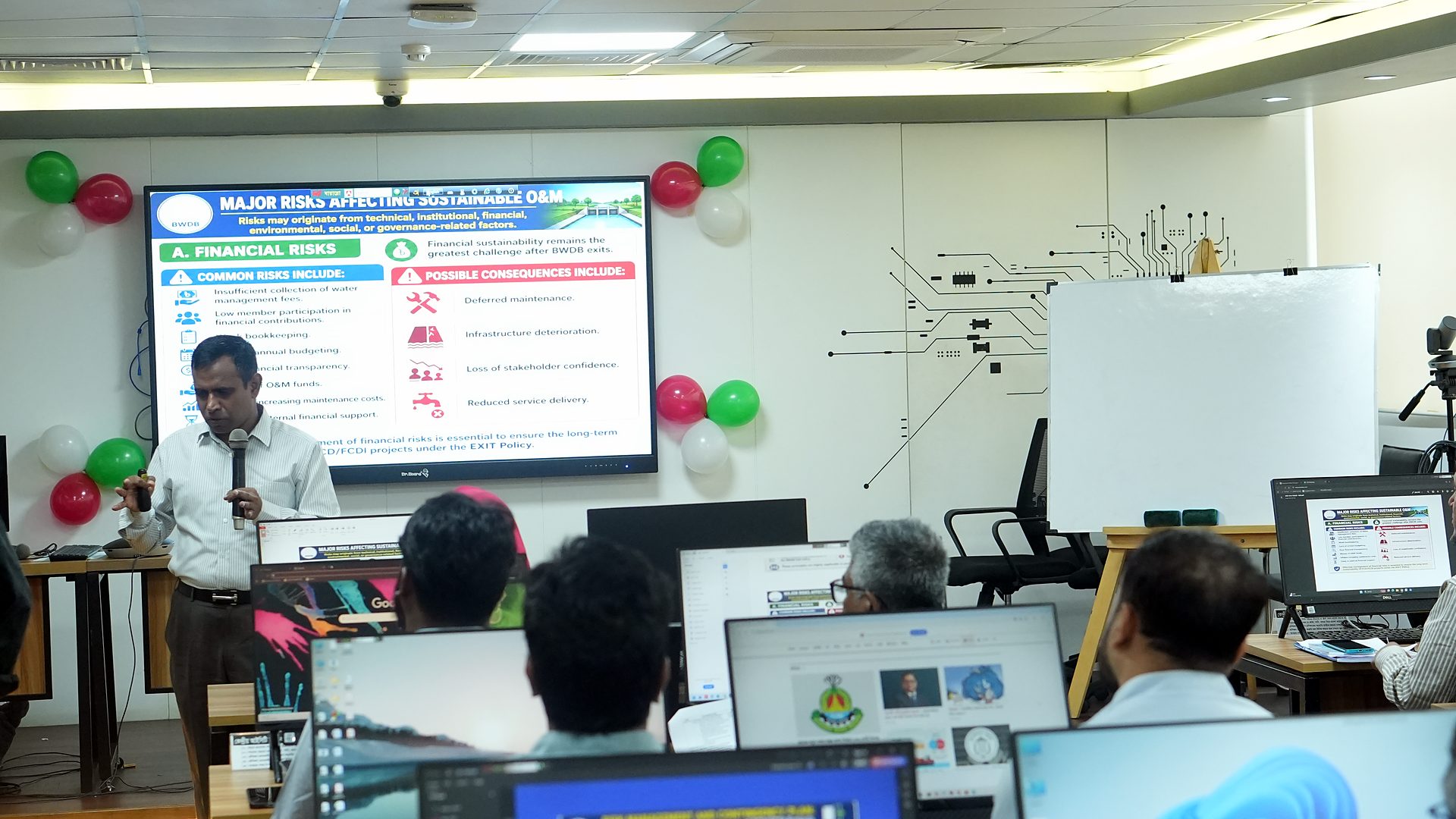 Participant presenting in front of a slide on the Central ICT Lab screen