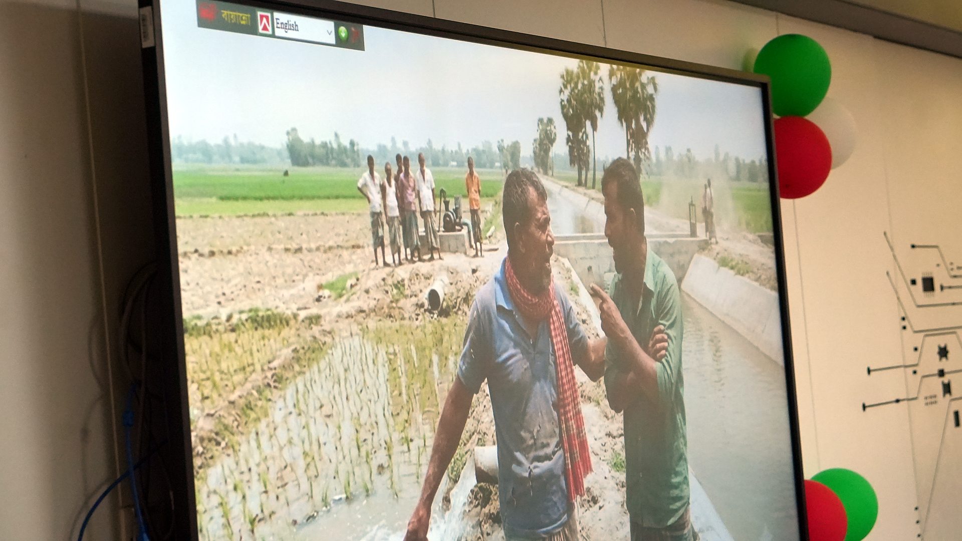 Photo of farmers and a field canal on the lab screen