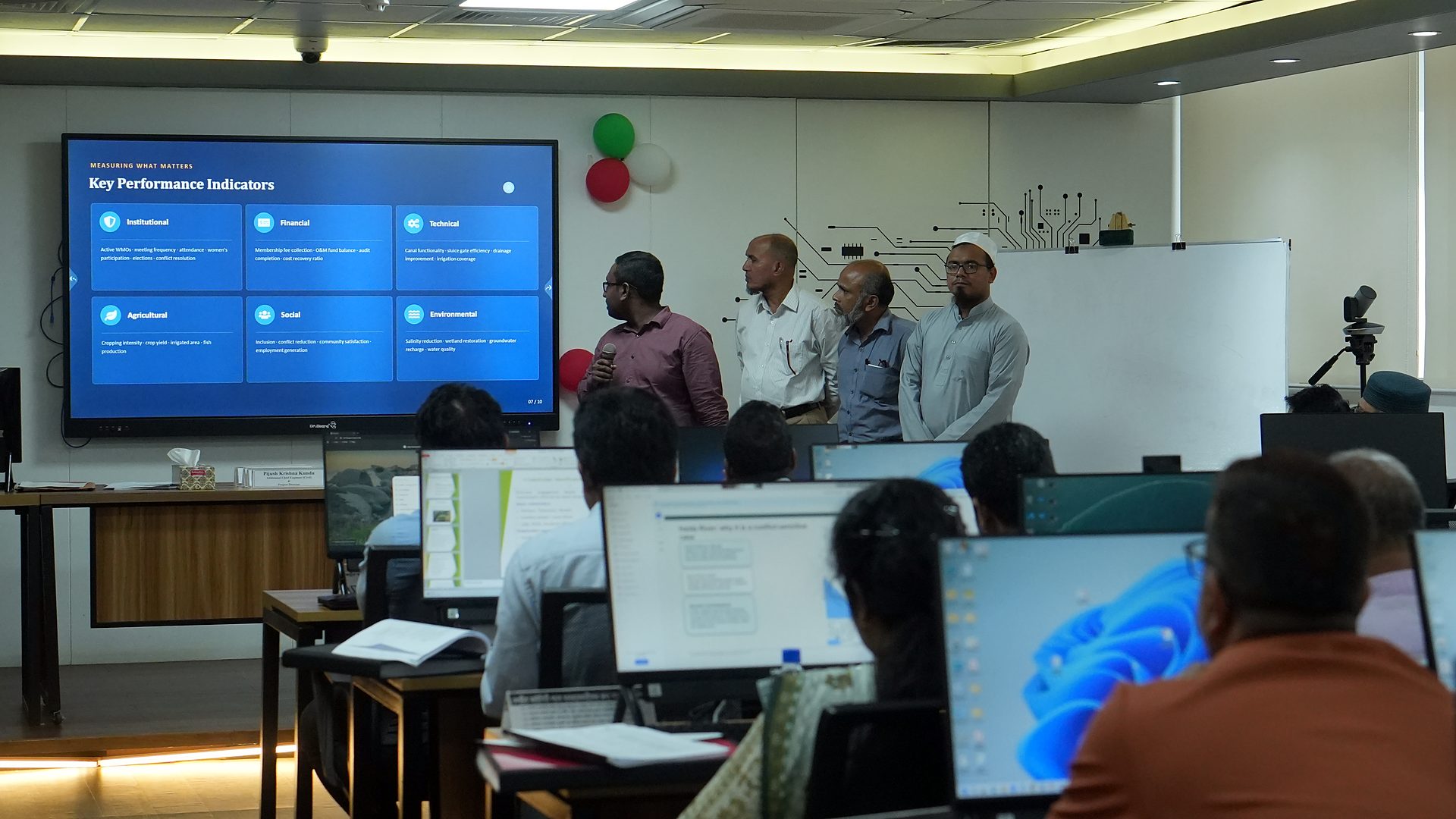 A group presenting key performance indicators on the lab screen