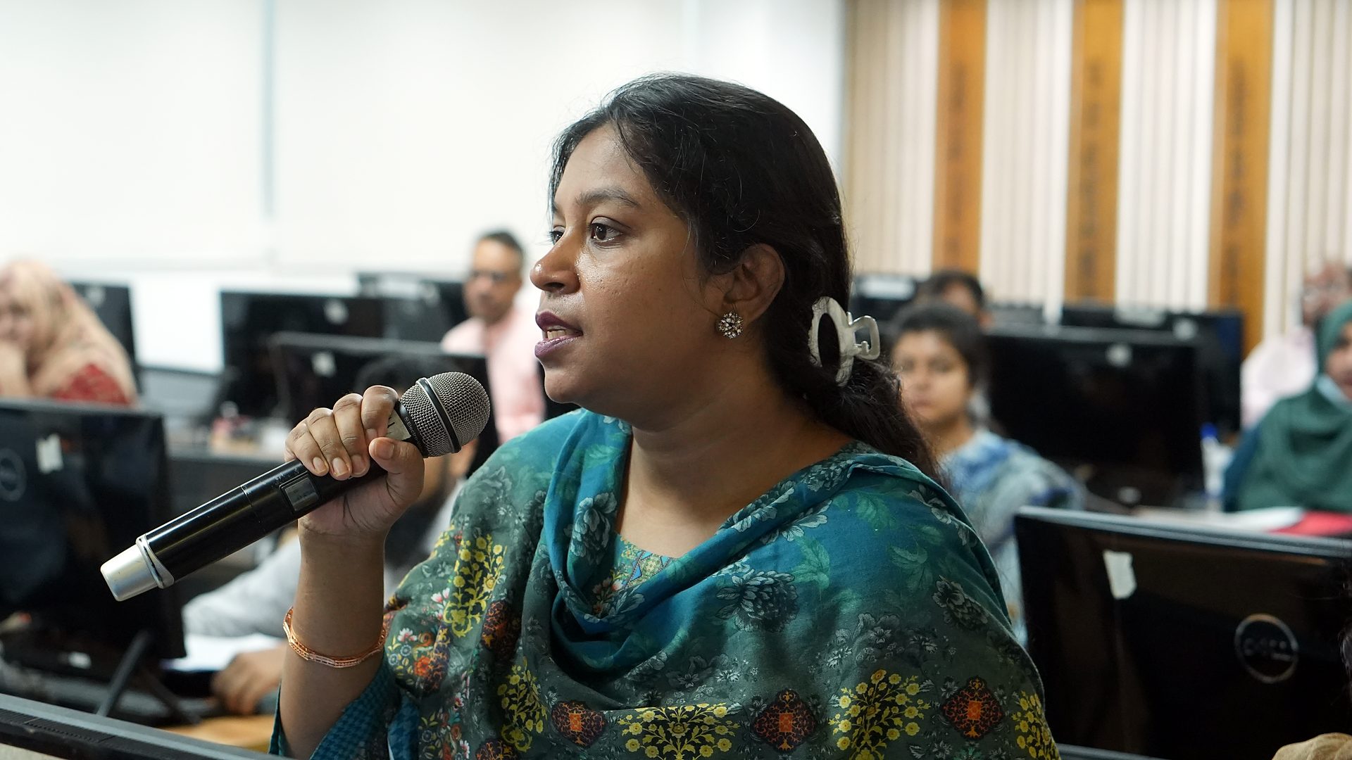 A participant speaking with a microphone during a session
