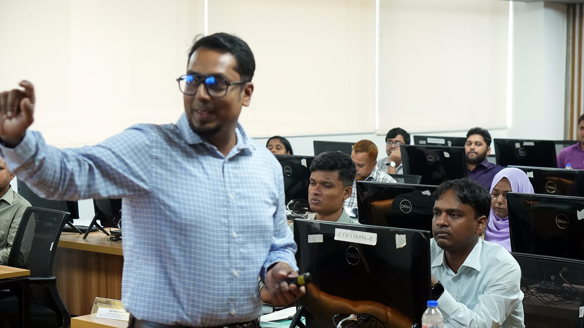 Resource person explaining GIS concepts among the workstations