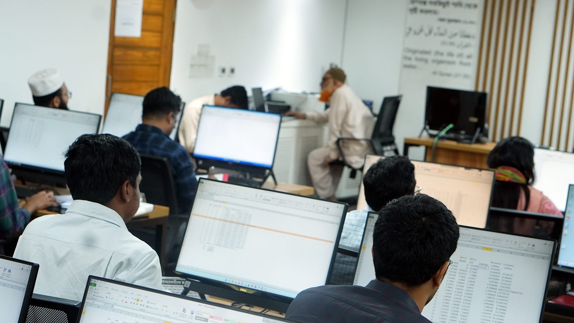 Participants working on spreadsheets at their workstations