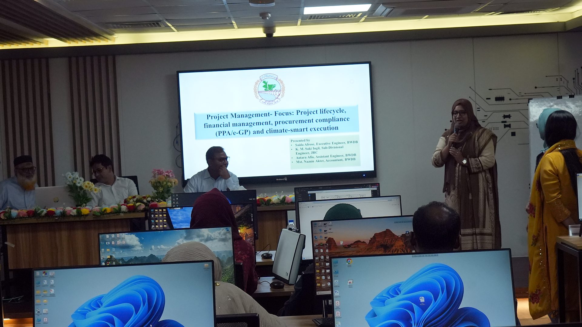 Team presenting with the course title slide on screen
