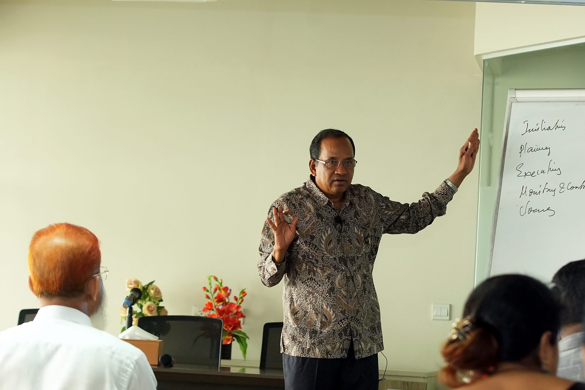 Trainer gesturing toward the flipchart