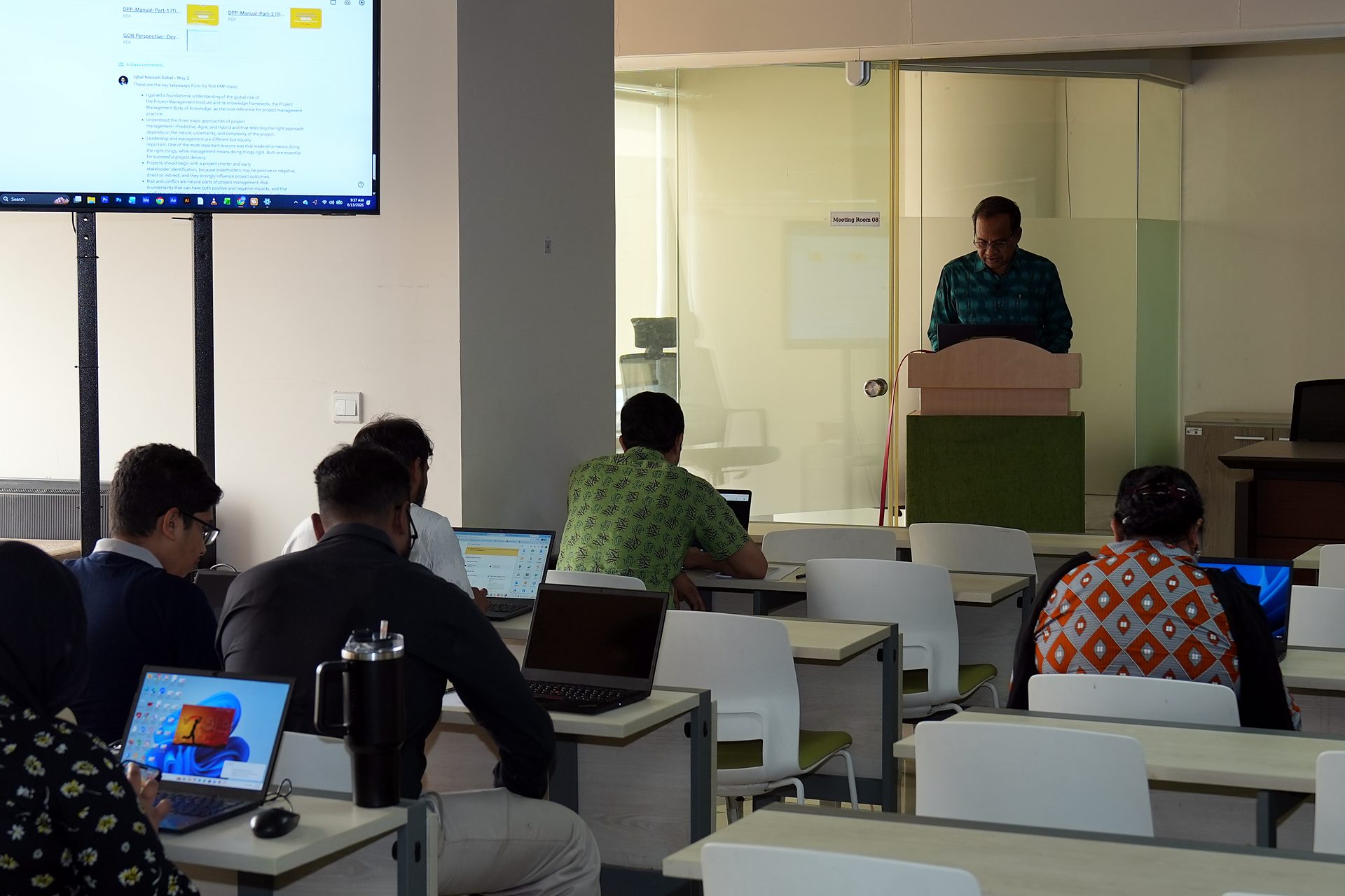 Trainer at the lectern with courseware on screen