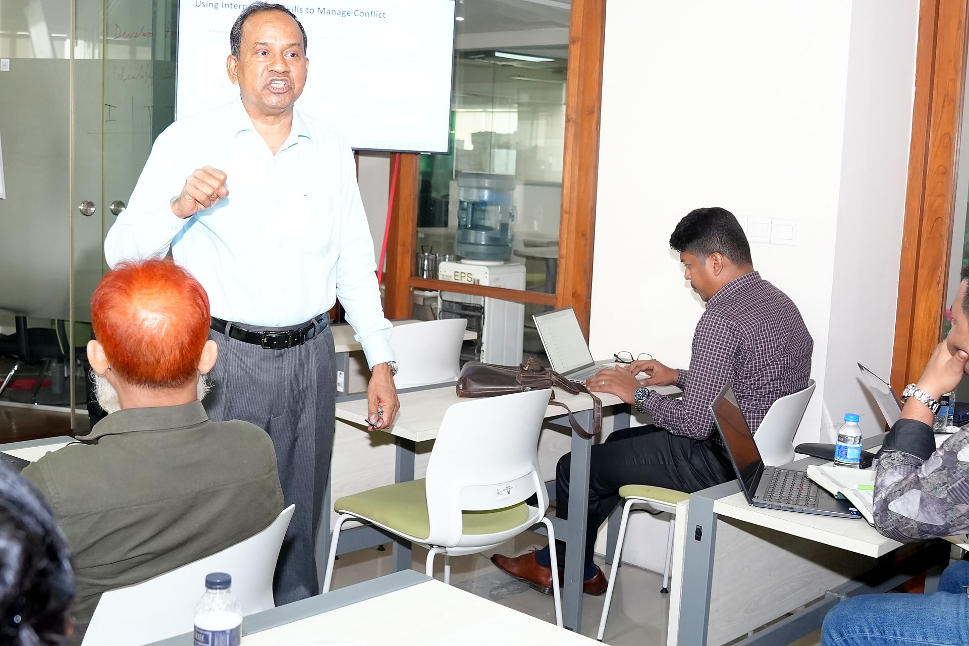 Trainer addressing participants among the desks